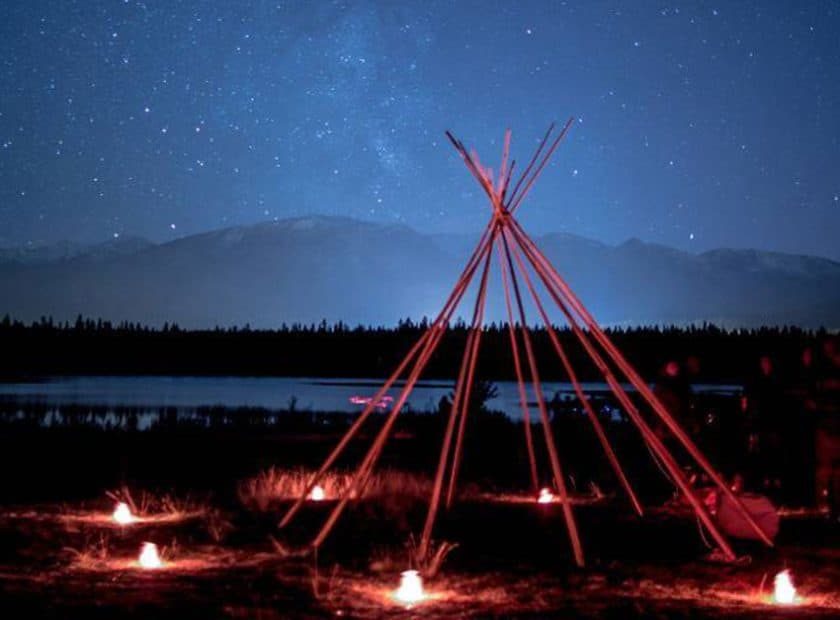 photo of teepee frame in the night sky